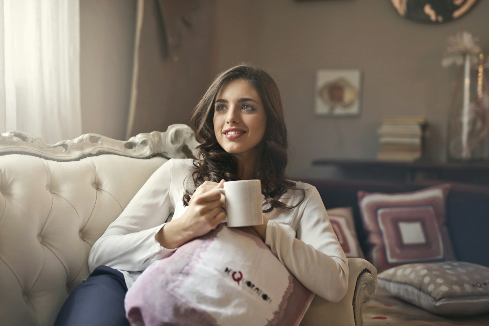 Photo by bruce mars woman holding mug sitting on sofa